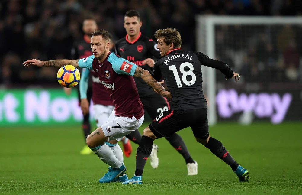 Marko Arnautovic (trái, West Ham) đi bóng quan Nacho Monreal (Arsenal). Ảnh: Getty Images.