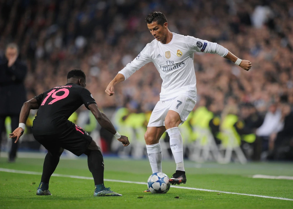 Cristiano Ronaldo (phải, Real Madrid) rê bóng trước hậu vệ PSG. Ảnh: Getty Images.