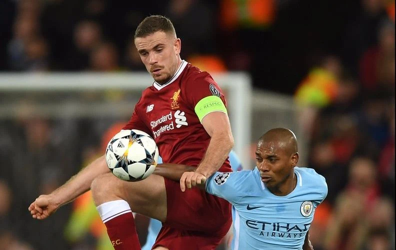 Jordan Henderson (trái, Liverpool) tranh bóng với Fernandinho (Manchester City) 