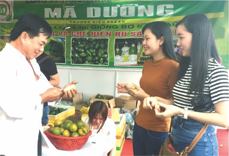 楊梓進(左)向顧客推銷有機水果。