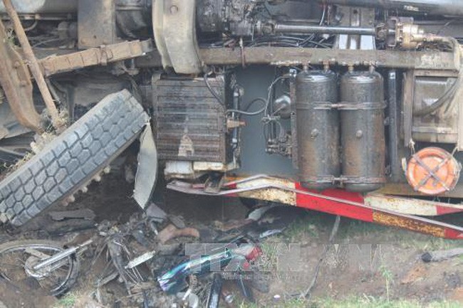 交通事故現場，卡車側翻壓扁摩托車，2人當場死亡。（圖源：潘軍/越通社）