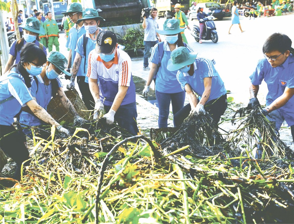本市共青團員打掃街道保護環境潔淨。(圖片來源:光定)