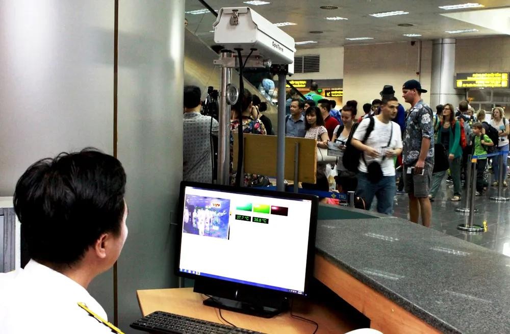 机场工作人员正在测量入境人员的体温。