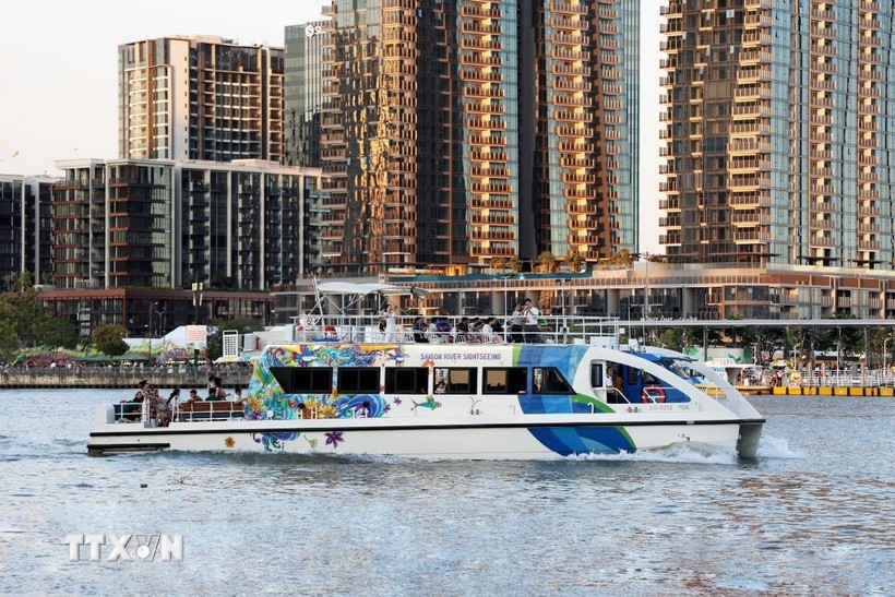 游客乘船在西贡河上参观胡志明市。