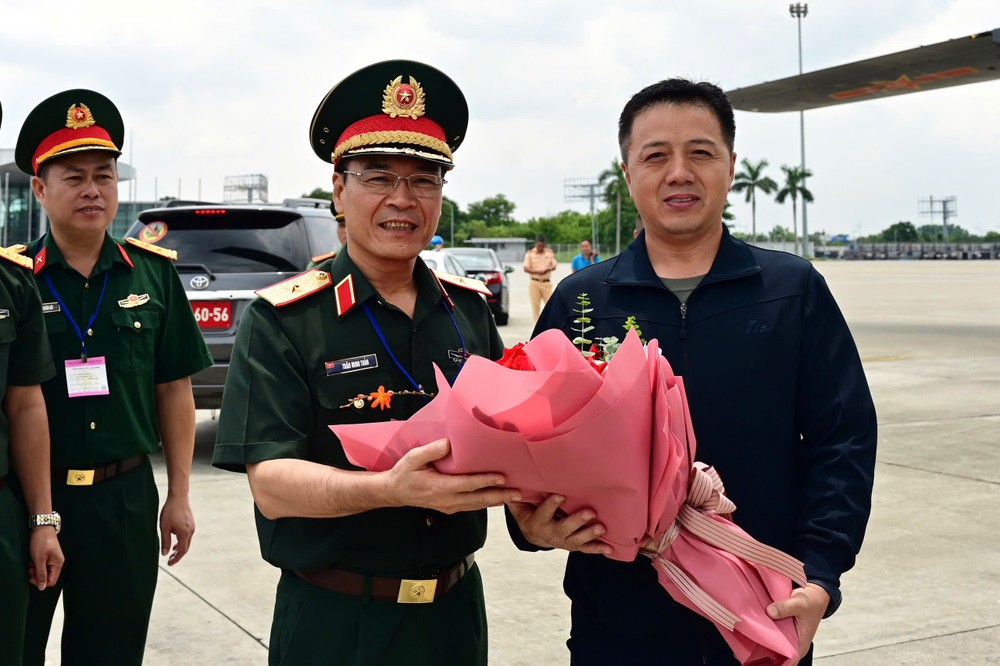 越南国防部代表向中国军人代表团赠送鲜花。