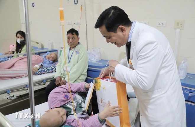 K医院领导向正在接受治疗的患者赠送礼物。