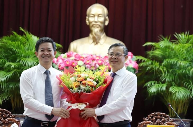 芹苴市委书记黎光松（左）赠送鲜花，祝贺张景宣同志当选芹苴市人委会主席。