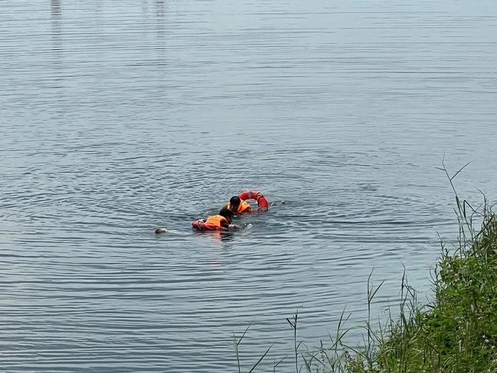 救援力量将男生遗体抬上岸。