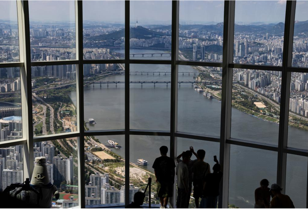 9月5日，游客在首尔的乐天世界塔的高层展望台俯瞰首尔的汉江。