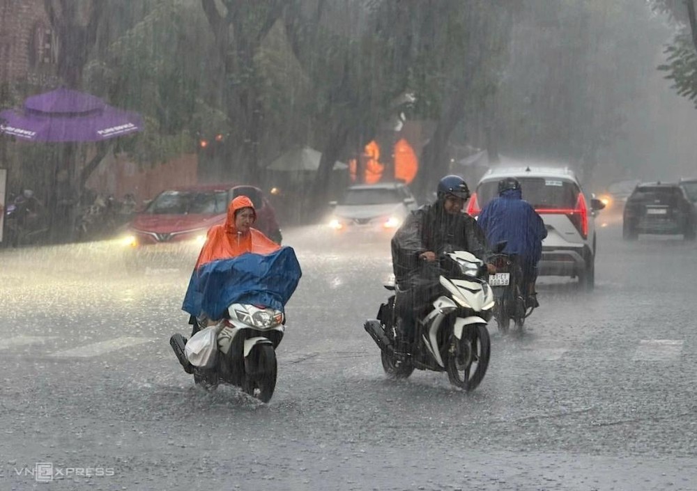 12月24日下午，在安庆坊春水街，民众在大雨中行驶。