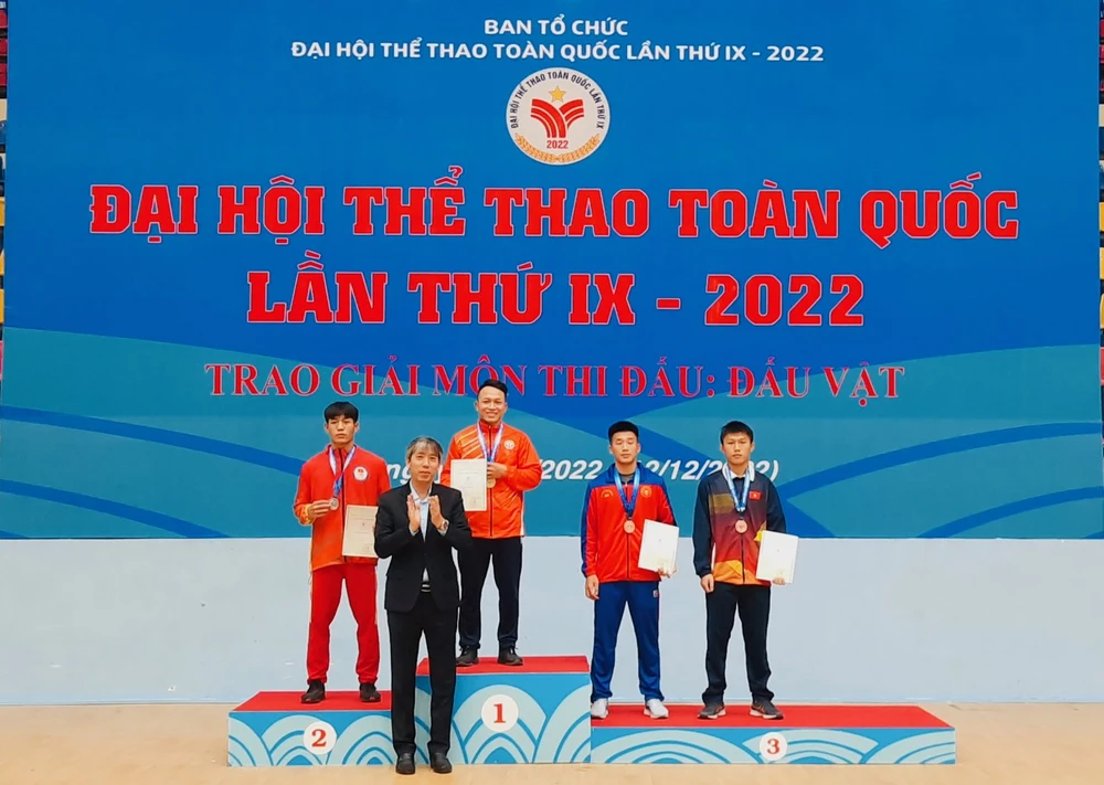 Ban tổ chức trao thưởng cho VĐV giành huy chương ở ngày đầu môn vật. Ảnh: V.QUỲNH