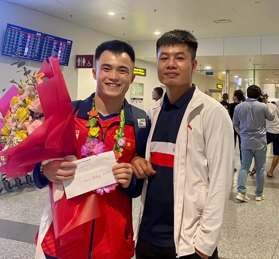 HLV Quyết và cậu học trò Nông Văn Hữu ngay tại sân bay Nội Bài. Ảnh: MINH MINH