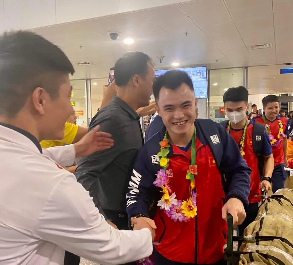 Thành viên đội tuyển wushu được người hâm mộ chào đón tại sân bay Nội Bài. Ảnh: MINH MINH