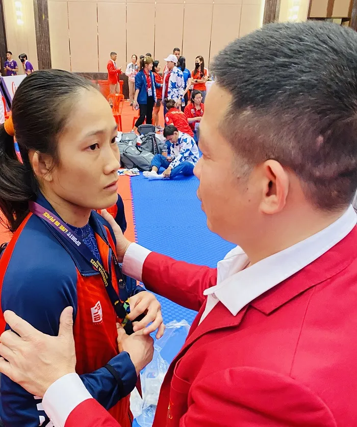 Võ sĩ Phùng Thị Huệ và HLV Bùi Đình Tiến có những trao đổi ngay tại SEA Games 32 về kế hoạch chuẩn bị cho ASIAD 19-2022. Ảnh: MINH MINH