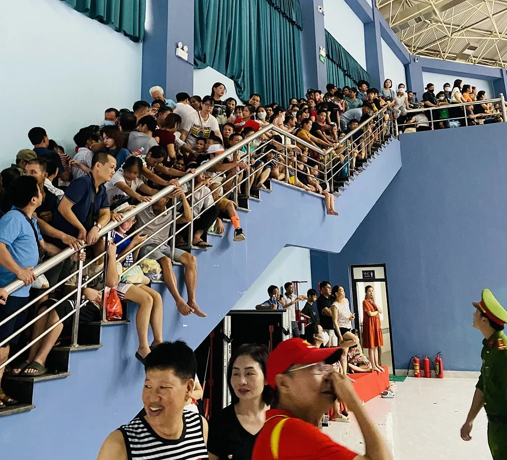 Khán giả ngồi kín hành lang lối đi trong nhà thi đấu thành phố Vĩnh Yên (Vĩnh Phúc) để chờ xem trận chung kết tối 6-8. Ảnh: MINH MINH Khán giả ngồi kín hành lang lối đi trong nhà thi đấu thành phố Vĩnh Yên (Vĩnh Phúc) để chờ xem trận chung kết tối 6-8. Ảnh: MINH MINH