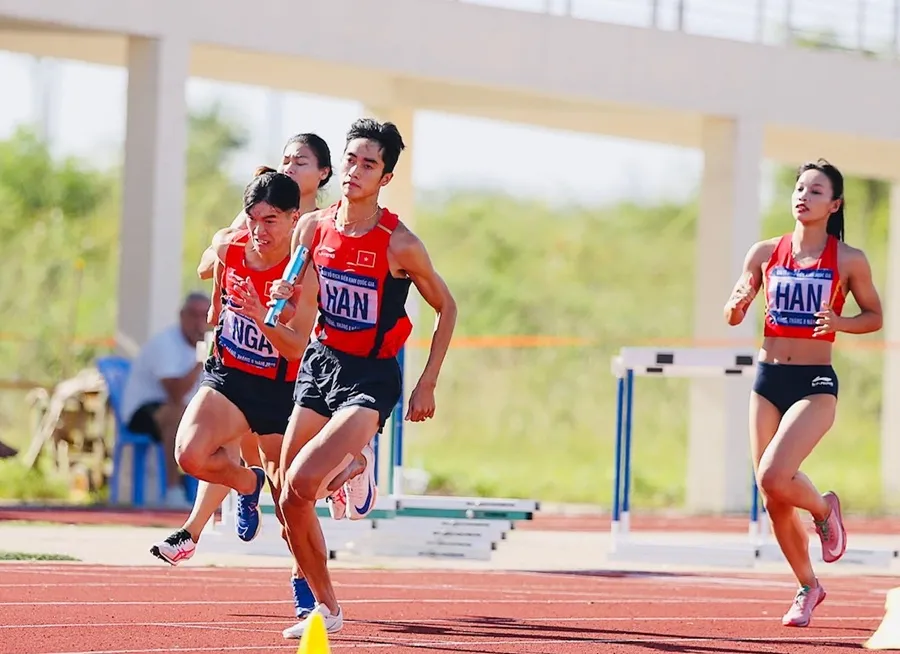 Các VĐV thi đấu tiếp sức hỗn hợp trong ngày tranh tài 12-8. Ảnh: HOÀNG TÙNG