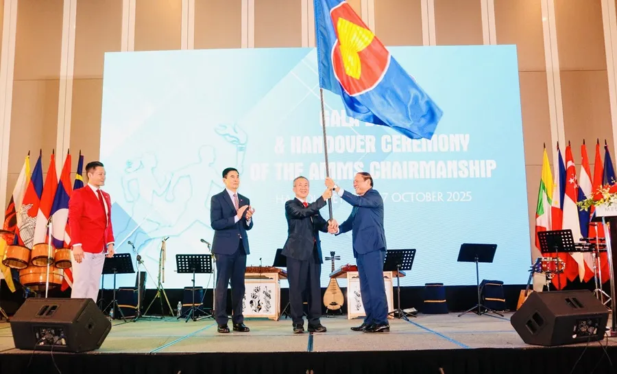 Bộ trưởng Nguyễn Văn Hùng trao cờ ASEAN cho quốc gia chủ nhà AMMS-9 là Campuchia. Ảnh: LƯỢNG LƯỢNG