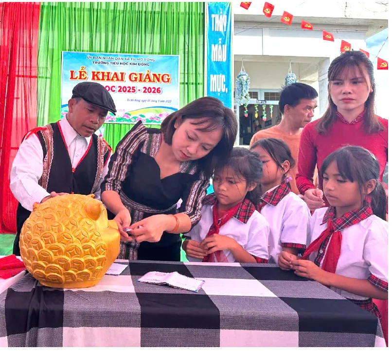 Trong khuôn khổ khai giảng, Trường Tiểu học Kim Đồng (xã Tu Mơ Rông, tỉnh Quảng Ngãi) phát động chương trình gây quỹ nuôi học sinh nghèo, mồ côi. Trong ảnh là giáo viên, học sinh tham gia bỏ heo đất gây quỹ. Ảnh: HPH uom mam con chu - 9.jpg