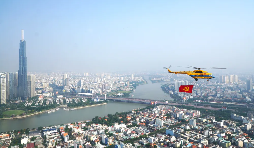 Máy bay trực thăng treo cờ Đảng bay trên nền trời TPHCM. Ảnh: THANH CHIÊU Dau an nhiem ky-TPHCM 30-4-1.jpg