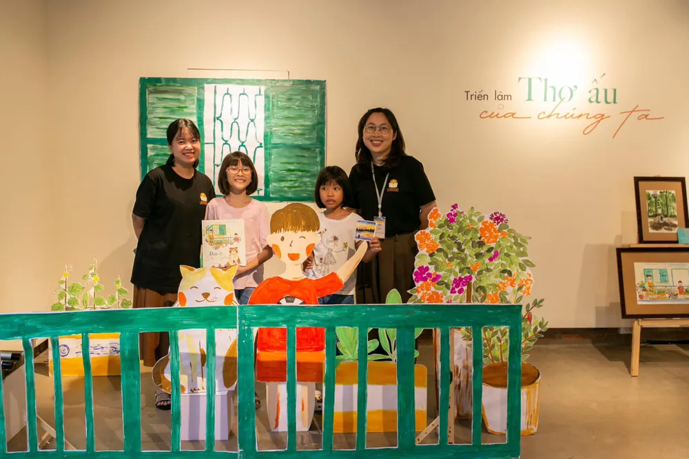 Tác giả Chiều Xuân (trái) cùng họa sĩ Cẩm Nhung chụp hình cùng các em nhỏ