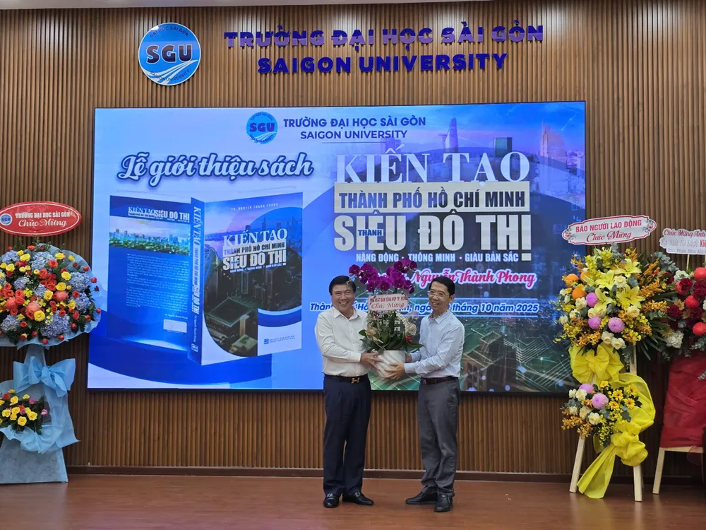 Ông Nguyễn Thành Lợi, Giám đốc - Tổng Biên tập NXB Tổng hợp TPHCM, tặng hoa cho tác giả, TS Nguyễn Thành Phong. Ảnh: QUỲNH MY z7101098493774_4d607d08add386c7d82230d21ad26511.jpg