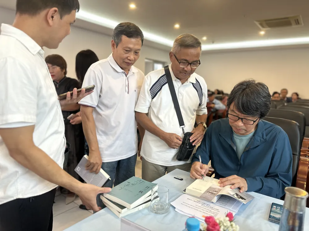 Nhà văn Lưu Chấn Vân ký tặng sách cho bạn đọc. Ảnh: QUỲNH YÊN IMG_5534.jpg