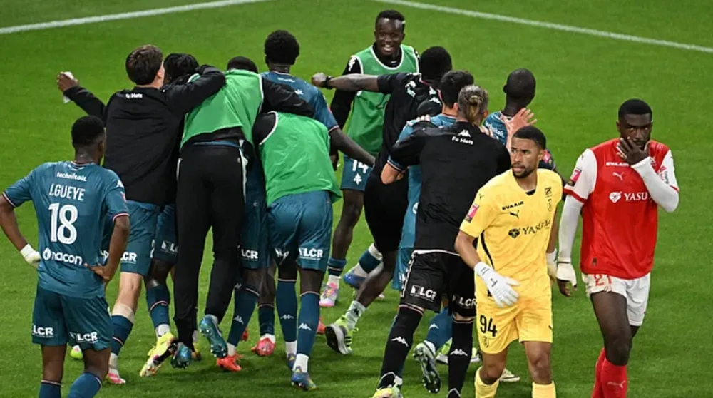 Reims (cầu thủ áo đỏ) thua Metz (cầu thủ áo xanh) 4-2 sau hai lượt play-off, chính thức xuống hạng sau mùa giải Ligue 1 2024/25. Ảnh: Outlook India Ảnh chụp màn hình 2025-05-30 133300.png