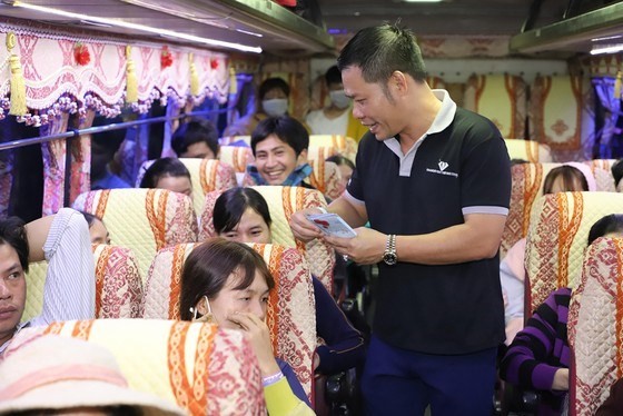 A volunteer supports passengers on coach No.7. (Photo: SGGP)