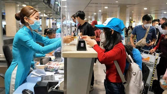 Passengers check in at Vietnam Airlines&apos; ticket counter. (Photo: SGGP)