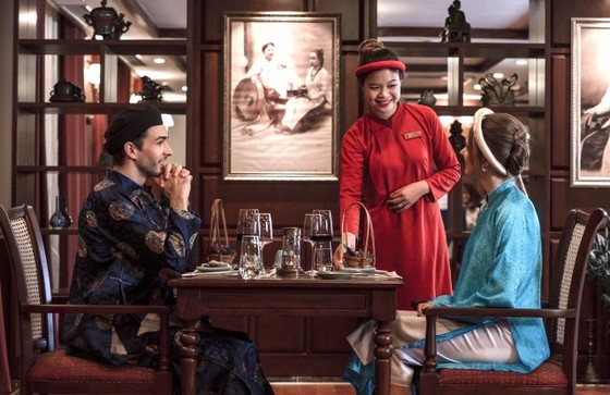 Foreign tourists experience Vietnamese culture by trying on traditional ao dai dresses during a visit to Lan Ha Bay on Cat Ba Island, Hai Phong City. (Photo: SGGP)