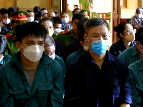 Hoang Duy Tien (wearing blue facemask) and his accomplices at court