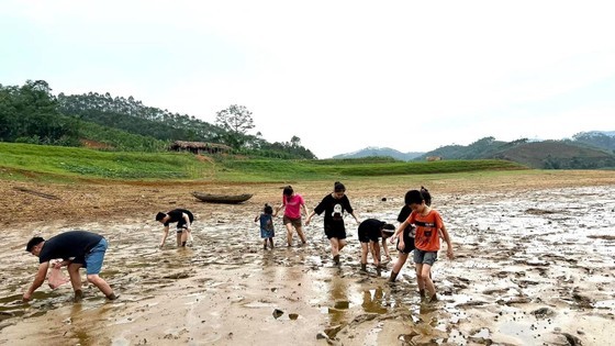 The local residents seize the opportunity to catch crabs, fish, and snails in the Thac Ba reservoir.