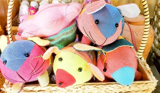 Stuffed animals and adhesive bags are crafted from discarded fabric scraps and leftover materials, repurposing them as recycled souvenirs for tourists.