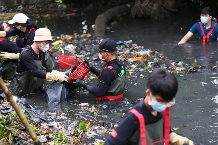 The members clean up the trash in the dark canal. Photo: Green Saigon The members clean up the trash in the dark canal. Photo: Green Saigon