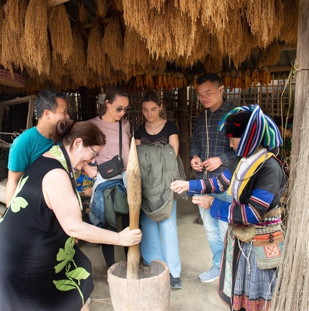 Foreign tourists seeing the making of the traditional linen cloth by Mong ethnic people in Quan Ba District, the Northern mountainous province of Ha Giang. (Photo: VNS)