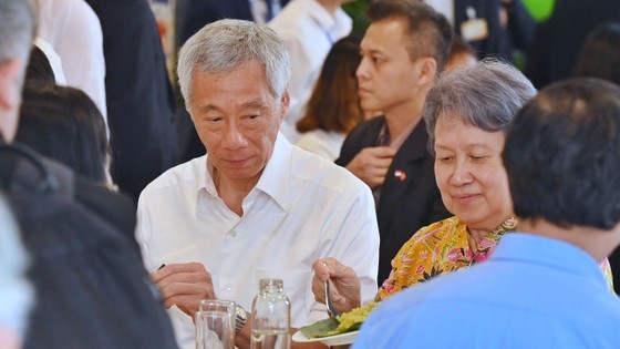 Prime Minister Pham Minh Chinh and Singaporean Prime Minister Lee Hsien Loong as well as their spouses and the students enjoy Vietnamese food at the university's canteen. (Photo: SGGP) Prime Minister Pham Minh Chinh and Singaporean Prime Minister Lee Hsien Loong as well as their spouses and the students enjoy Vietnamese food at the university's canteen. (Photo: SGGP)