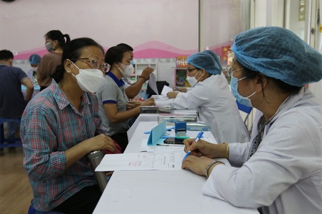 Doctors diagnosing patients in HCMC. The city's most significant current challenge is the scarcity of healthcare personnel at the grassroots level. (Photo: VNS) 325693-4739581663796903-vna-potal-tp-ho-chi-minh-kham-benh-mien-phi-cho-500-nguoi-lao-dong-6693448-6633.jpg