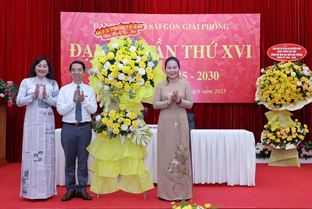 Ms. Le Thi Hong Nga (R) presents flowers on behalf of the Party Committee of Ho Chi Minh City Party Agencies to congratulate the congress. 27-6-5-2165-6108.jpg.jpg