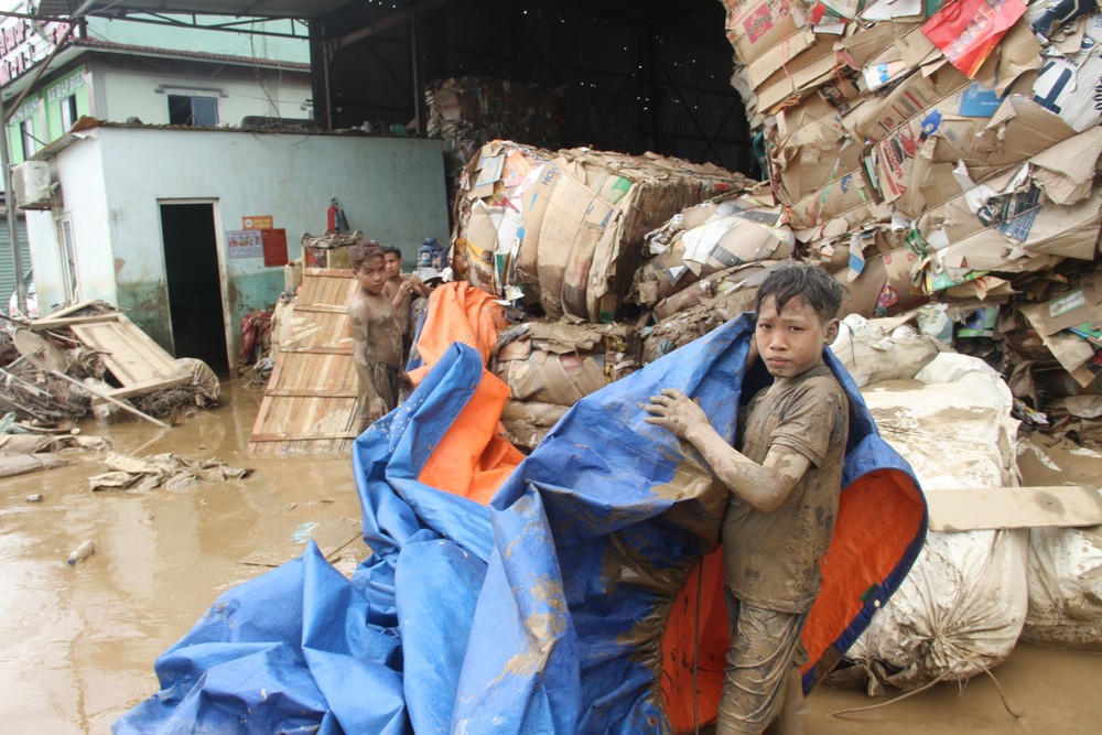 Children covered in mud help their families clean up in the aftermath of the flood. img-7086-2125-171.jpg.jpg