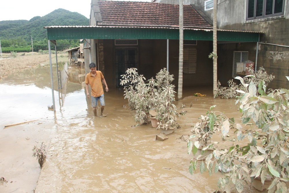 Nguyen Minh Duc, a resident of Tien Thanh Hamlet, stands by his home still surrounded by thick mud. img-7106-2822-1603.jpg.jpg