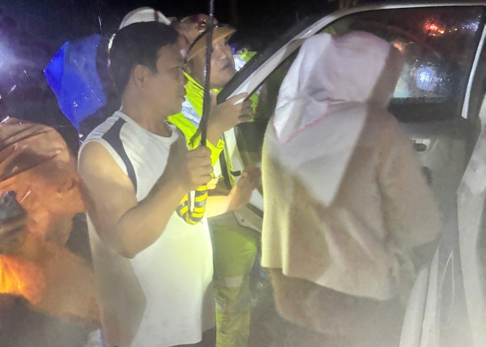 Traffic police and local residents help a mother and her child through the flooded area to receive emergency medical care. 27-10-da-nang-csgt-963-2140.jpg.jpg