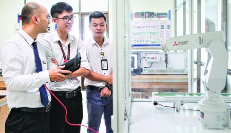 Students of the automation major in their practice lesson to control robots. (Photo: SGGP)