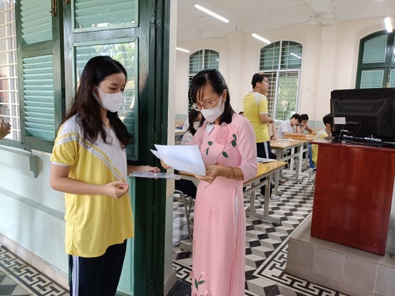 A proctor is reading aloud contestants’ names for them to enter the test room (Photo: SGGP)
