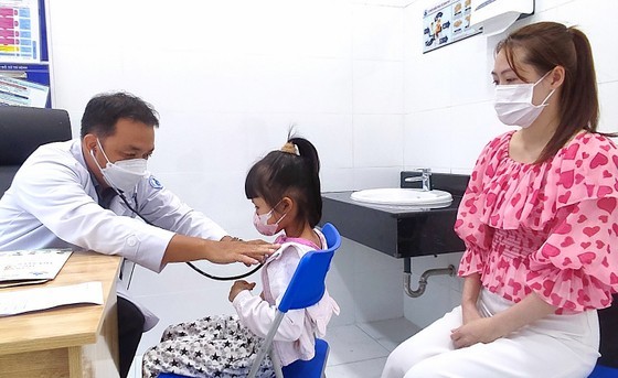 Level-2 Specialist Nguyen Hong Phong from Children Hospital No.1 is treating a child