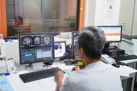 A technician in Cho Ray Hospital is taking an MRI scan for a patient