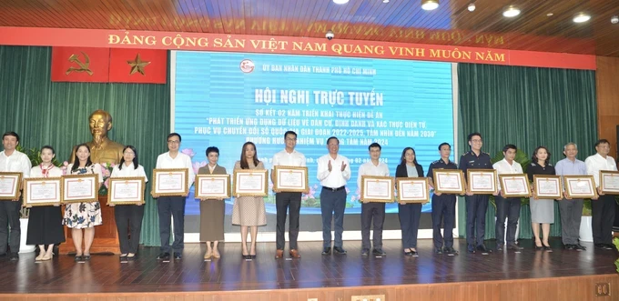 Chairman Phan Van Mai of the HCMC People’s Committee is delivering certificates of merits to individuals and groups with outstanding achievements (Photo: SGGP) 30b-9294.jpg