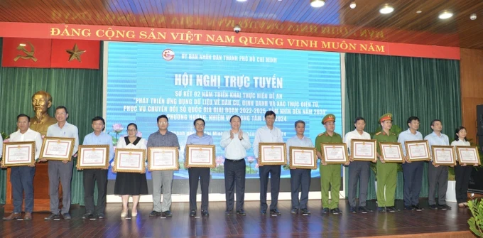 Chairman Phan Van Mai of the HCMC People’s Committee is delivering certificates of merits to individuals and groups with outstanding achievements (Photo: SGGP) 30c-3881.jpg