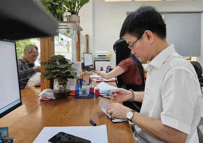 The chairman of the Ward 1 People’s Committee (Go Van District, HCMC) is signing an administrative paper (Photo: SGGP) 40b.jpg