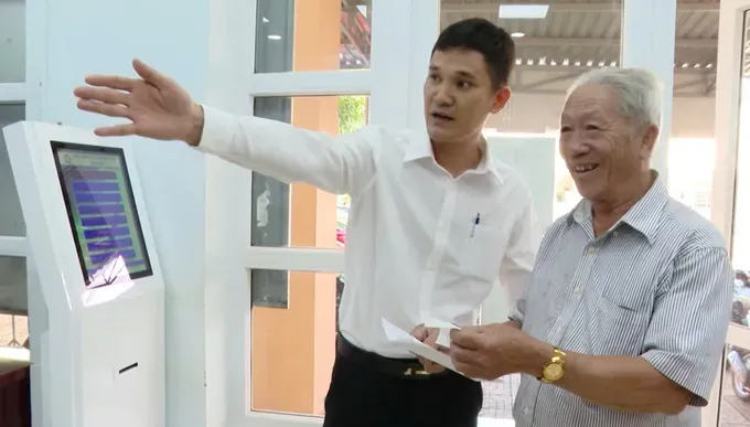 An official at the Hoa Hiep Commune Public Administration Service Center is guiding a resident through an administrative procedure (Photo: SGGP) 04c.jpg