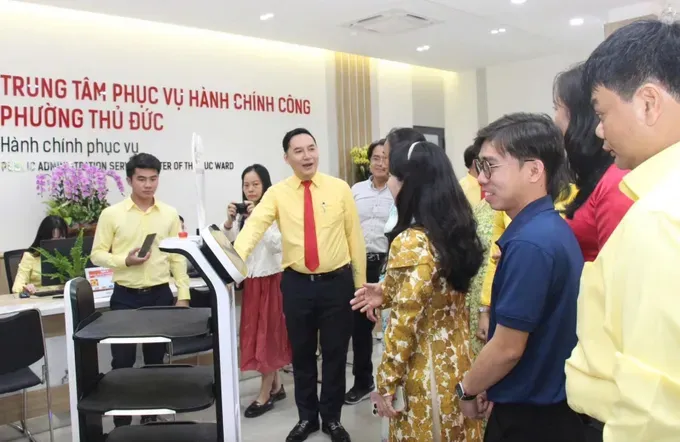 A robot is aiding residents with obtaining a queue number at the Public Administration Service Center in Thu Duc Ward (Photo: SGGP) 04e.jpg